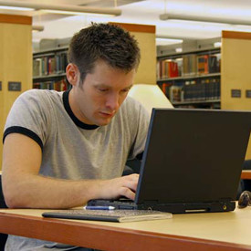 young man at a laptop in a library