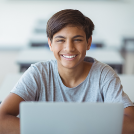 Smiling boy working at computer